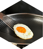 Fried egg on a fork over a non-stick frying pan.